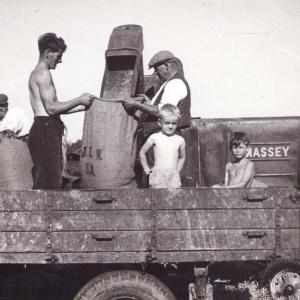 1950s Trinity Hall Farm Herbert Daines holding the sack on the right Bob Saltmarsh boy left
