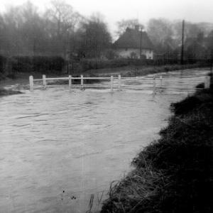 1965 approx Brookside in flood with the old little bridge.